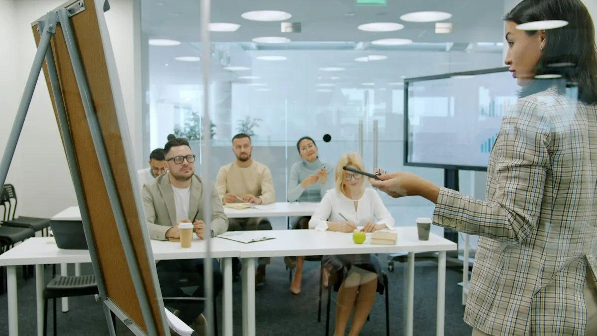 A presenter at a flip chart in front of a seated group in a conference room